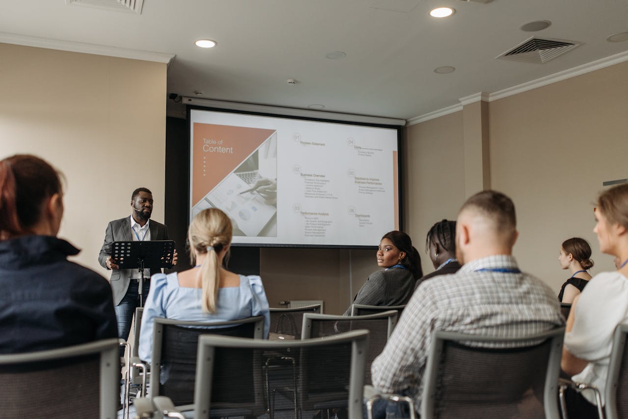 Audience attentively listening to a business presentation in a conference room setting.